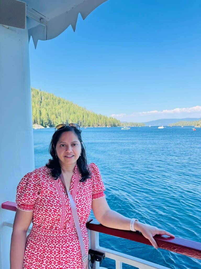 A girl posing on a boat with blue lake in the backdrop