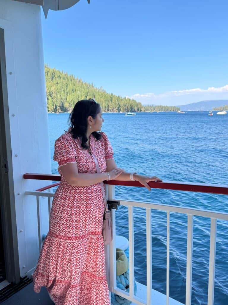 A girl looking at the views from a boat deck with blue lake in the backdrop