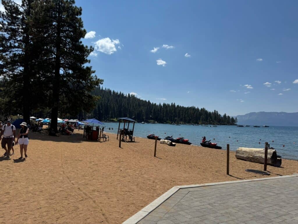 Beach at Lake Tahoe with mountains and trees in the background