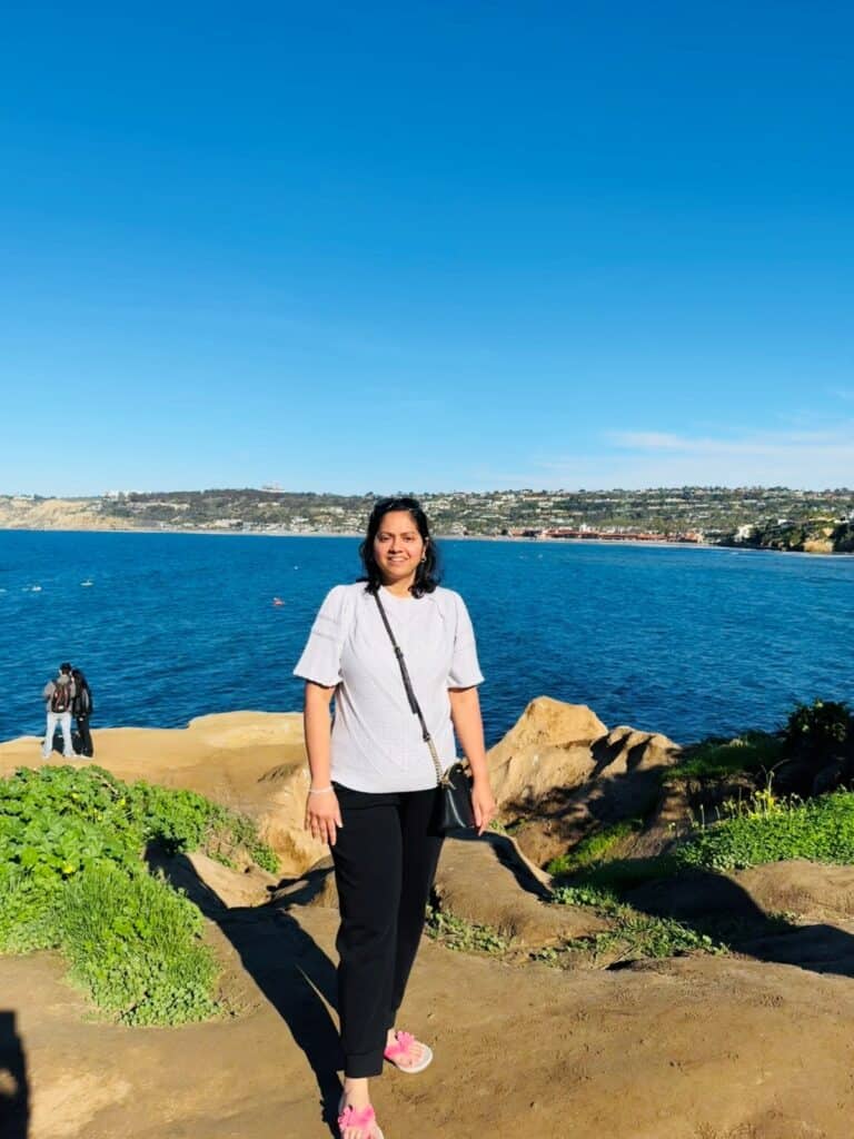 A girl posing on a rocky cliff in LA Jolla Cove, San Diego